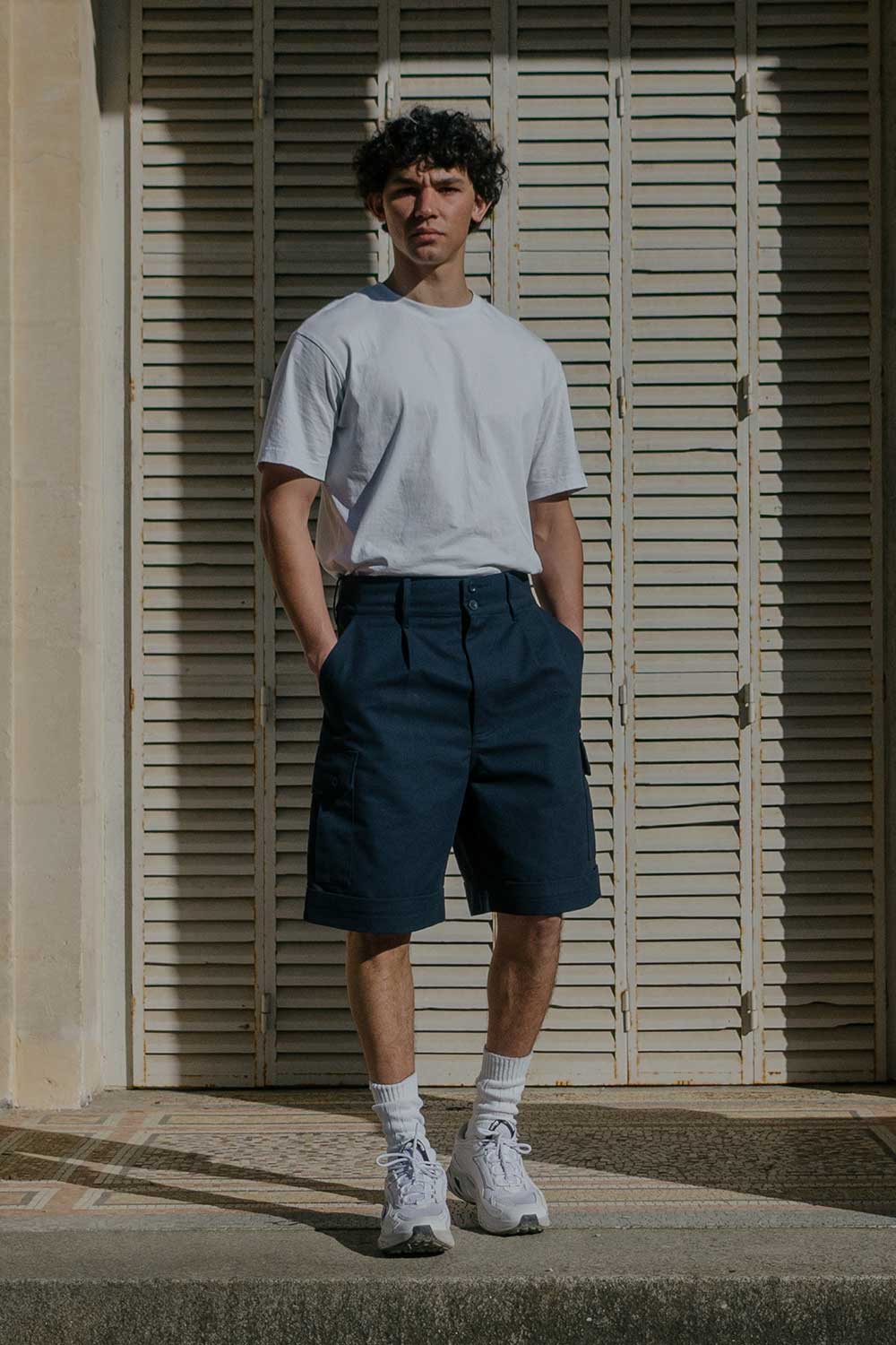 Homme de face de plein pied portant le bermuda cargo marine de LATER...